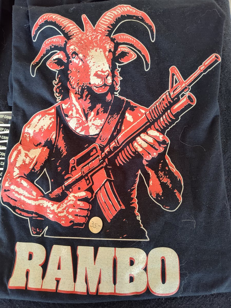 Black tee with a churro ram drawn as 'Rambo' holding a rifle