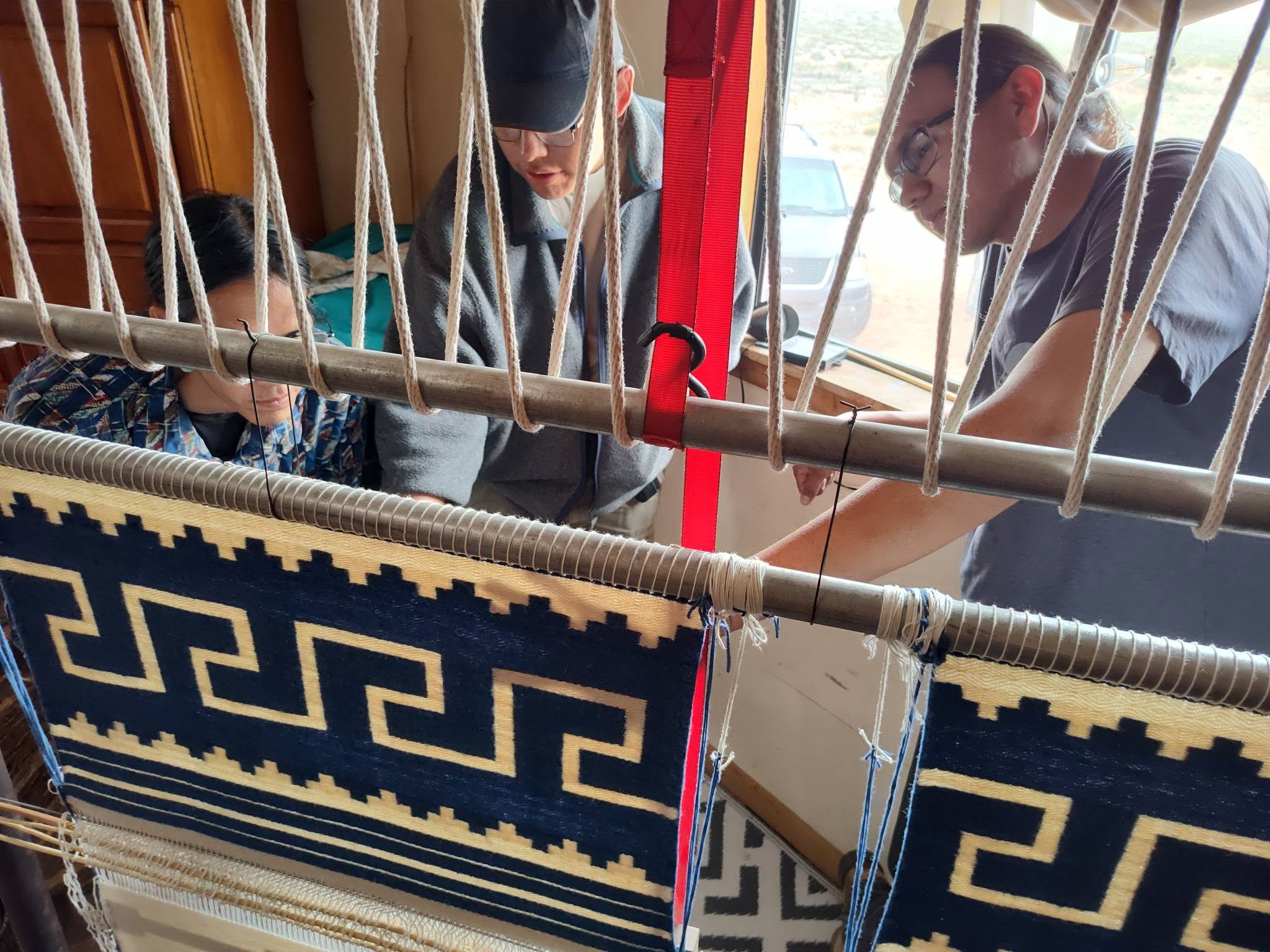 Apprentices at the upright loom